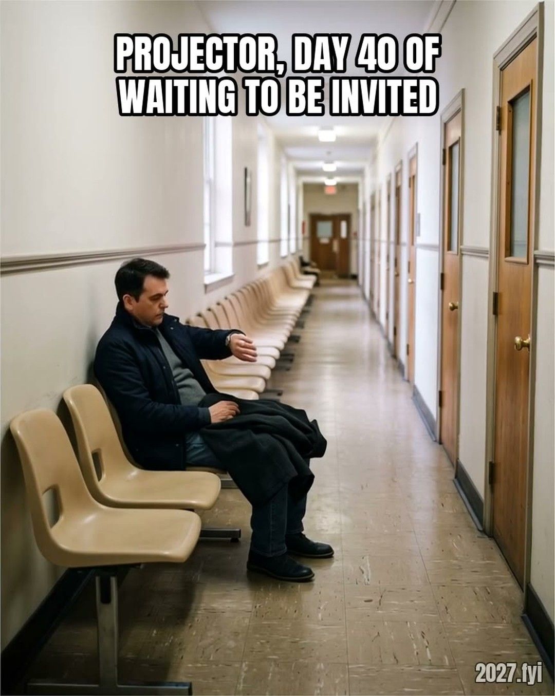 A man waits alone on a long row of chairs in an empty corridor and checks his watch again and again. Label: PROJECTOR, DAY 40 OF WAITING TO BE INVITED